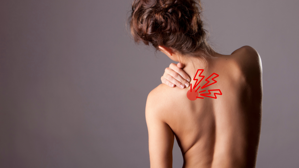 A Woman Grabbing at her Shoulder with Should Blade Knot Pain