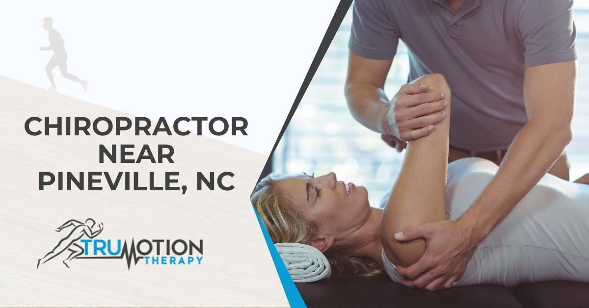A Chiropractor Helping a Woman Laying on Her Back With Shoulder Pain | Chiropractor Near Pineville, NC | TruMotion Therapy